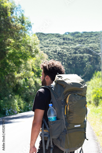 young man with a travel backpack in a beautiful landscape