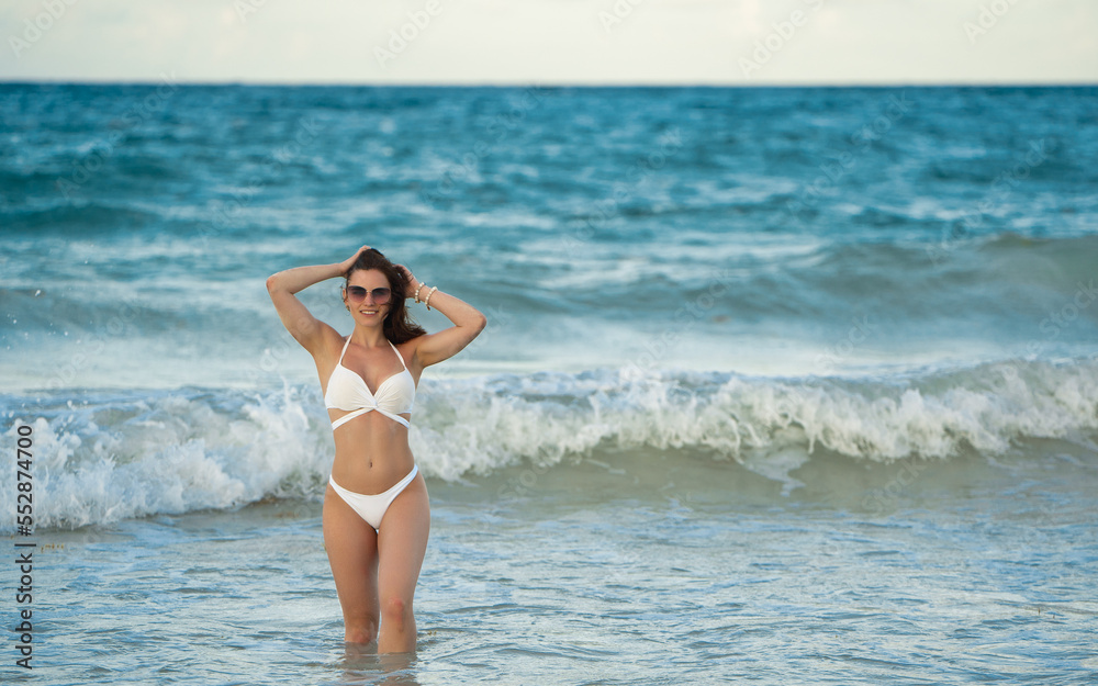 Female at Punta Cana beach posing in the white bikini