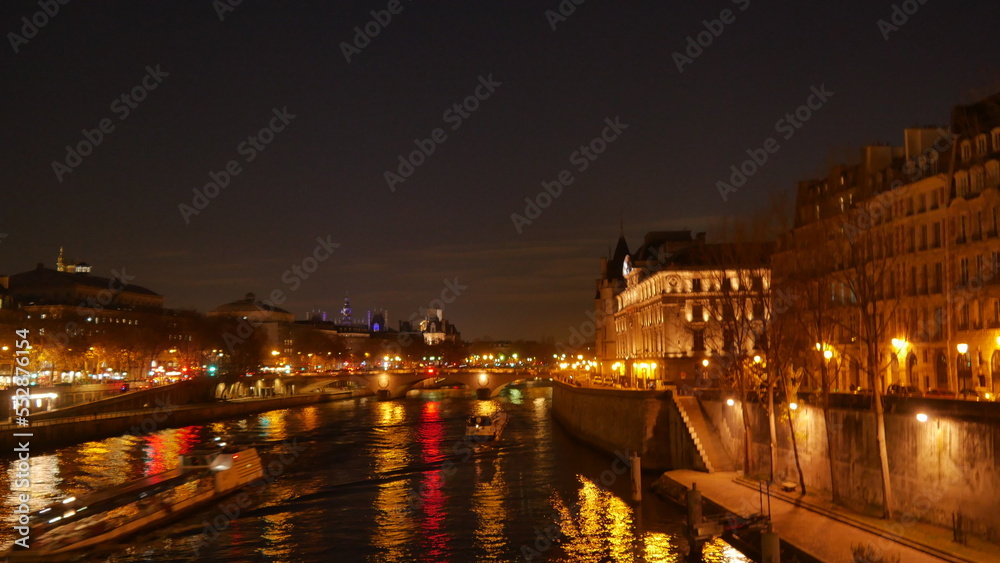 Promenade au bord de la Seine pendant une soirée, saison d'automne, sous un fort éclairage jaune des lampadaires, côté urbain, marche tranquille et silencieuse, beauté des bâtiments historique