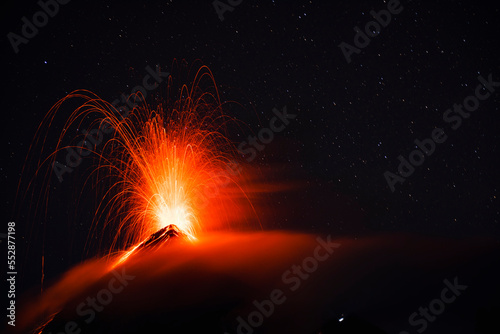 Fuego eruption over clouds and stars photo