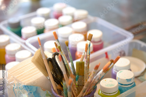 different brushes for drawing in a jar on a blurry background child creativity concept.