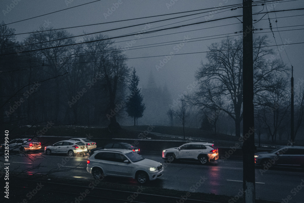 Traffic in the evening in the fog against the background of a prayer house in the city of Vinnitsa, Ukraine