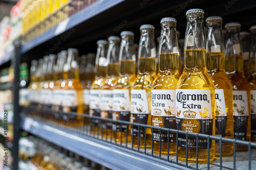 Corona extra beer bottles on shelves in a supermarket. Corona Extra is a pale lager produced by