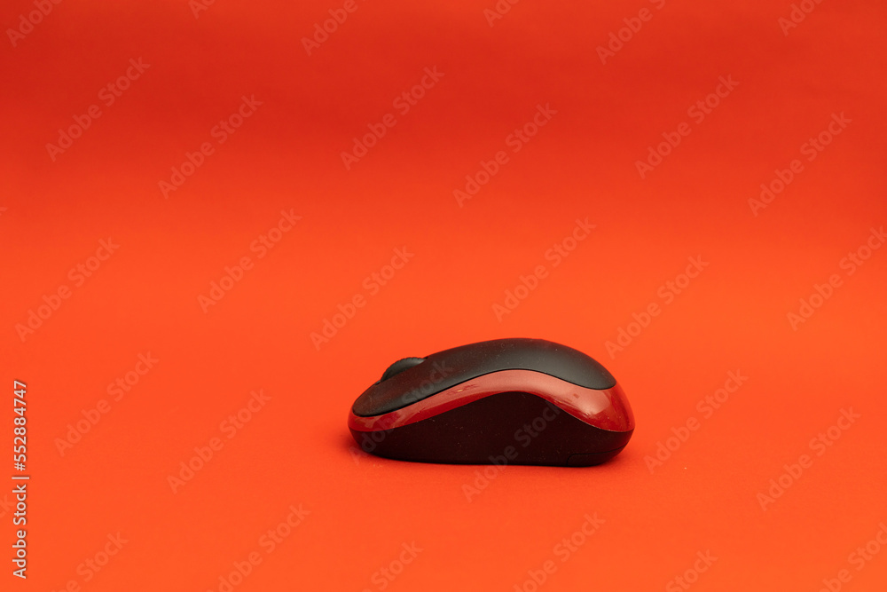 Black computer mouse on red background Black computer mouse on red background