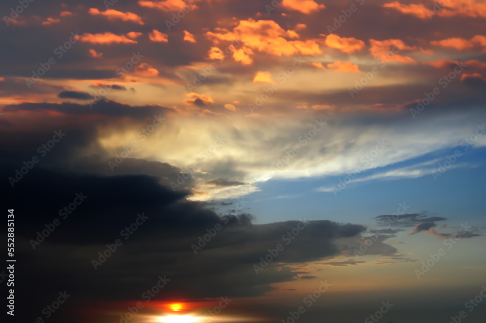   orange sunse on night blue sky dramatic clouds and sun flares , nature seascape 