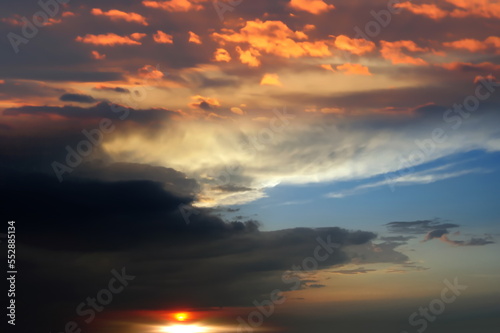  orange sunse on night blue sky dramatic clouds and sun flares , nature seascape 
