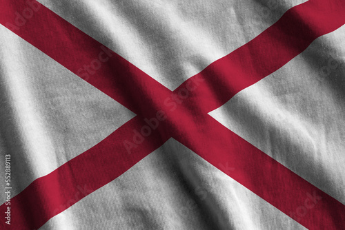 Alabama US state flag with big folds waving close up under the studio light indoors. The official symbols and colors in fabric banner photo