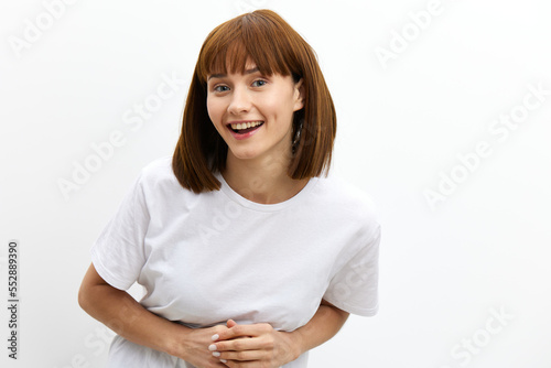 a sweet, pleasant, happy woman stands on a white background in white flour and leans towards the camera smiling broadly. Horizontal photo with an empty space for inserting an advertising layout