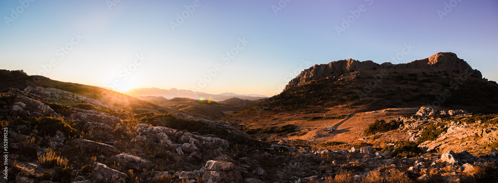 Panoramic view of a valley at sunset with camper vans