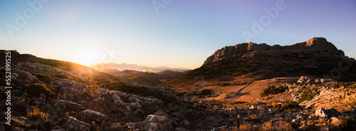 Panoramic view of a valley at sunset with camper vans
