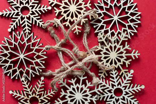 collection of wooden snowflake ornaments with twine on red