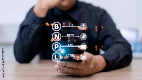 Businessmen holding a smartphone with icons of BNPL with online shopping icons technology. BNPL Buy now pay later online shopping concept.