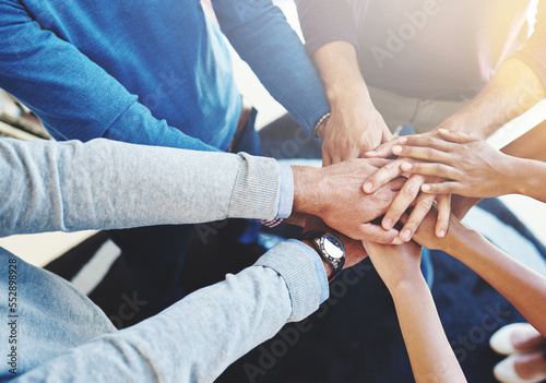 Their secret is great teamwork. Cropped shot of a group of businesspeople standing in a huddle with their hands stacked.