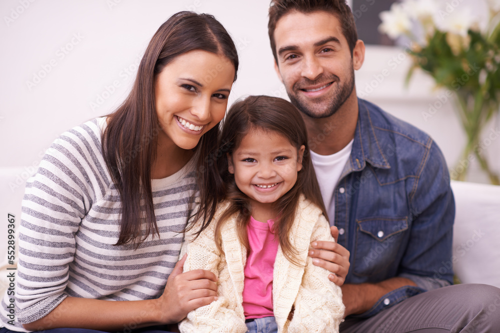 Theyre a family built on the foundation of love. Portrait of a happy young family sitting together at home. Theyre a family built on the foundation of love. Portrait of a happy young family sitting together at home.