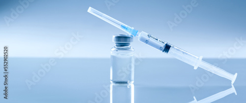 Medical syringe with a needle and a bollte with vaccine.