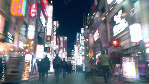 Tokyo, Japan - December 9, 2022: hyper lapse video of urban nightlife in Asian metropolis, crowd of people walking along illuminated streets of entertainment district Kabukicho in Tokyo photo