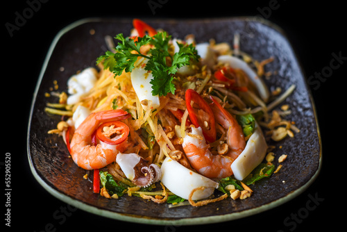 Salad made of shrimps and squid isolated on black background side view
