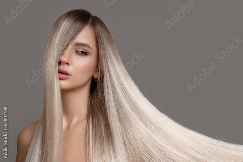 Portrait of a beautiful woman with long straight hair and makeup. Flying blonde hair