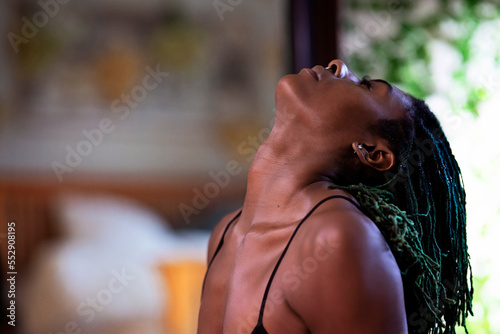 Black woman with dreadlocks spending time practicing yoga meditating and stretching