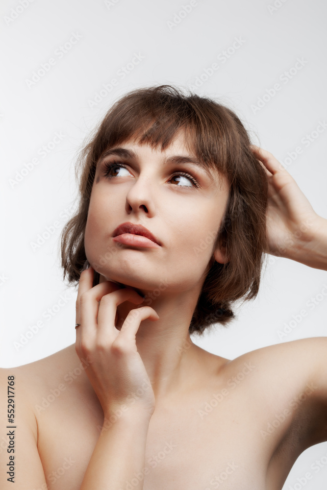 studio portrait of a beautiful brunette girl with short hair looking up isolated on white background. studio portrait of a beautiful brunette girl with short hair looking up isolated on white background.