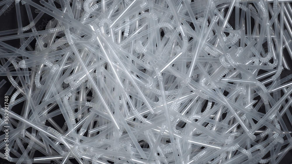 Straws made of plastic for drinking. Disposable plastic spinning on the table. Background, for Say no to plastic campaign and awareness. Pollution of the environment and ecology. Plastic straws ban. Straws made of plastic for drinking. Disposable plastic spinning on the table. Background, for Say no to plastic campaign and awareness. Pollution of the environment and ecology. Plastic straws ban.