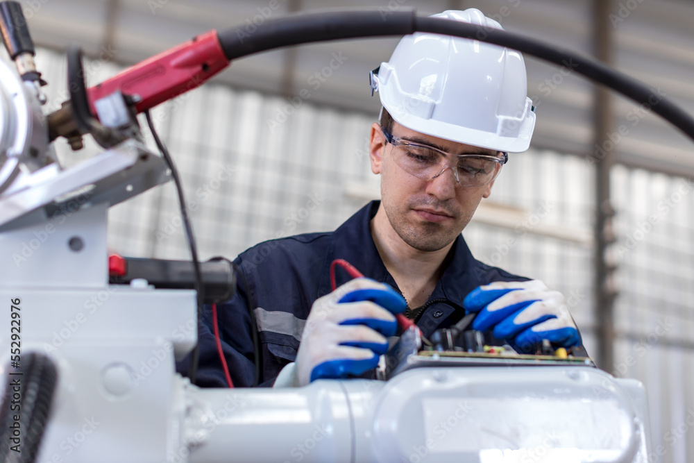 Engineer or Worker in intelligent factory industrial. Engineer check and control automation robot arms machine in intelligent factory industrial Engineer or Worker in intelligent factory industrial. Engineer check and control automation robot arms machine in intelligent factory industrial