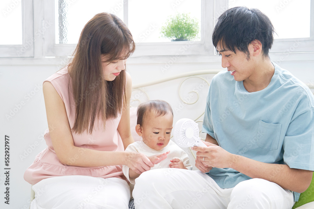赤ちゃんにハンディファンを使う父親