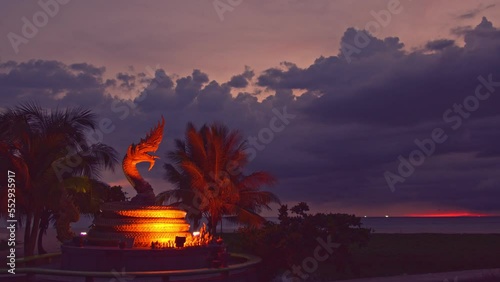 ..Scenery sunset behind Naka god of snake statue in the middle of Karon beach Phuket..Karon beach is a beach is broad and long. .Sand and beautiful beach suitable for swimming..cloud scape background. photo