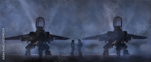 Fighter Pilots next to 2 military Fighter jets on a smoky runway discussing combat mission. Dramatic silhouette of 2 aircrew and their fighter bombers with missiles and bombs. NATO peace keeping photo