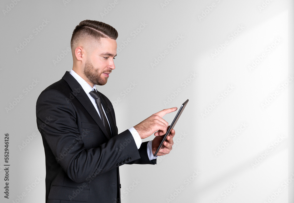 Businessman working with tablet, copy space grey background Businessman working with tablet, copy space grey background