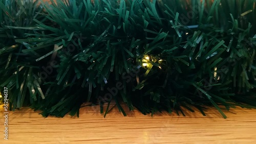 shimmering christmas garlands wrapped in green tinsel on a wooden background