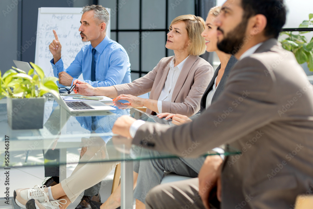 Business team discussing together business plans in office. Business team discussing together business plans in office.
