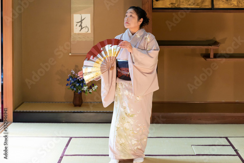 着物姿で扇子を持って日本舞踊を踊る年配の日本人女性 photo