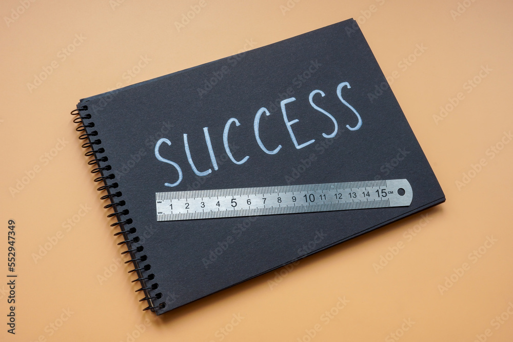 Notepad with the inscription success and a ruler for measuring it.