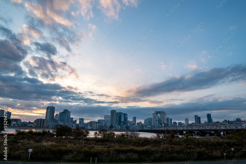Fototapeta premium View of a park with buildings and a river in the background during sunrise