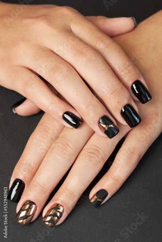 female manicure on a black background. nail. nails. Women s hands with a beautiful manicure on a black background. Beautiful female hands on a dark background. Take care of your hand.