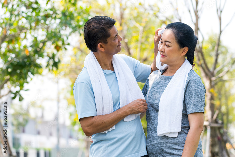 happy couple asian elder take care and support after jogging running with smile in park