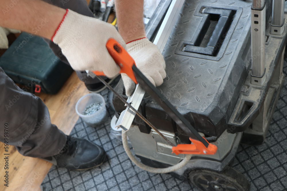 Fototapeta premium worker performs work on trimming and installs a metal plate and fitting