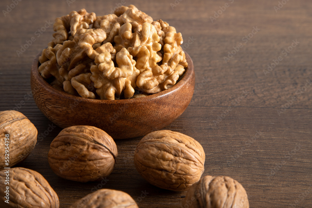 Peeled walnuts and whole walnuts in wooden bowl
Peeled walnuts and whole walnuts in wooden bowl