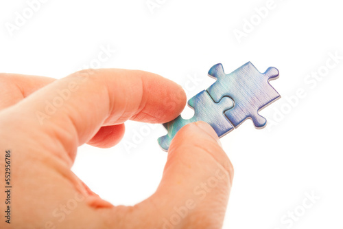 hand connecting two jigsaw puzzle pieces, isolated