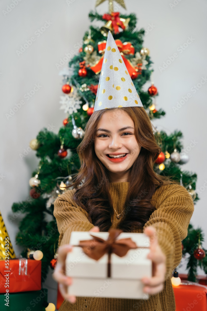 Asian young happy girl and decorate Christmas tree. Young women to celebrate holiday Xmas thanksgiving party in living room in house. Asian young happy girl and decorate Christmas tree. Young women to celebrate holiday Xmas thanksgiving party in living room in house.