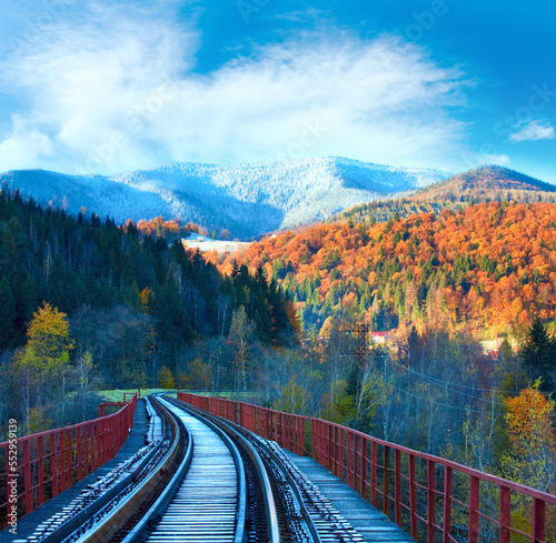 Railway on bridge and first autumn snow on far mountains
