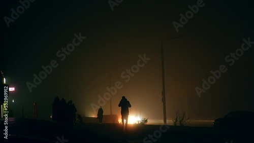 Silhouettes of people in the darkness of the streets at blackout time. War in Ukraine and crisis in energetic system from power stations bombing. photo