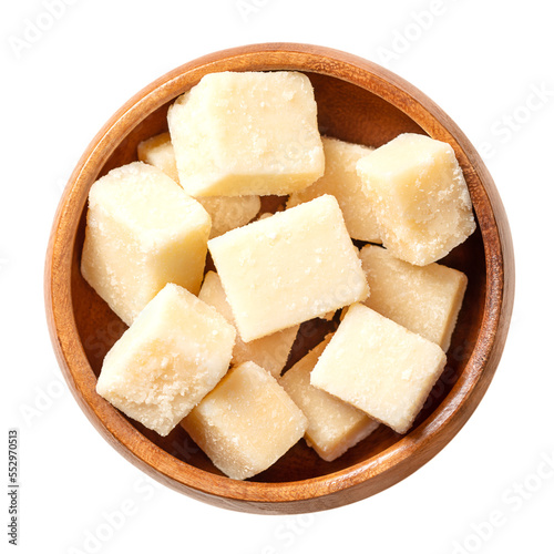 Grana Padano cheese cubes, in a wooden bowl. Italian hard cheese chunks, similar to Parmesan, crumbly-textured, with strong savory flavor and slightly gritty texture, made from unpasteurized cow milk.