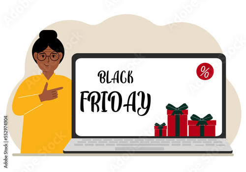 A woman next to a large laptop, on his screen the text black friday and a lot of gift boxes.