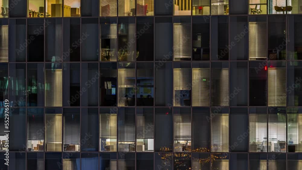 Night aerial view of office building glass window facade with illuminated lighted workspace rooms timelapse. Glowing and blinking light in skyscraper Night aerial view of office building glass window facade with illuminated lighted workspace rooms timelapse. Glowing and blinking light in skyscraper