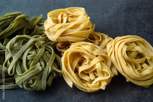 Fresh homemade green and yellow pasta tagliatelle. Raw homemade spinach pasta.