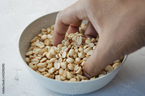 hand pick Processed peanuts in a bowl on table 