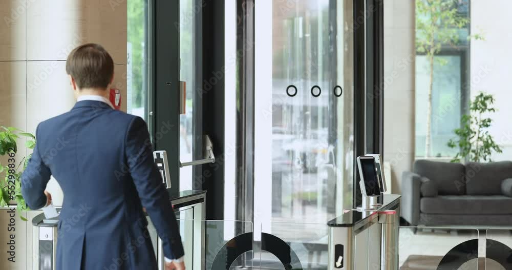 Businesspeople in formal wear going at lunch break, using electronic card reader, leaving modern corporate office building area passing through automatic security turnstiles gateway. Working day ended