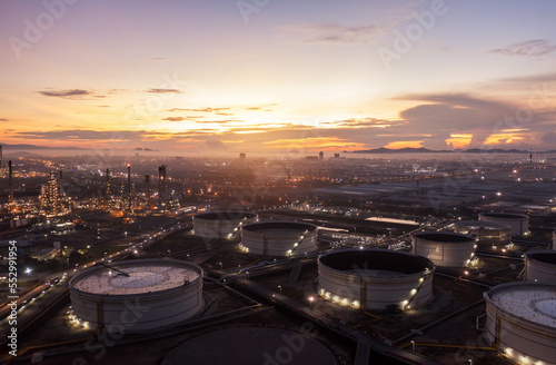 Aerial view drone of oil storage tank with oil refinery factory industrial. Oil refinery plant at beautiful sky sunset and twilight. industry factory concept and transportation.